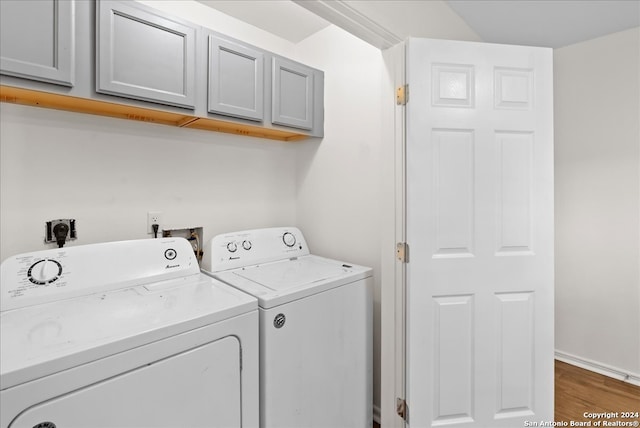 laundry room with washer and dryer, dark wood-type flooring, and cabinets