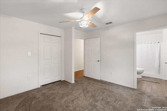 unfurnished bedroom featuring carpet flooring, ceiling fan, ensuite bathroom, and a closet