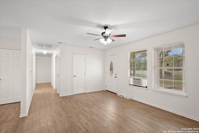 spare room with ceiling fan, light hardwood / wood-style floors, and cooling unit