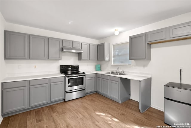 kitchen with gray cabinets, sink, stainless steel appliances, and light hardwood / wood-style flooring