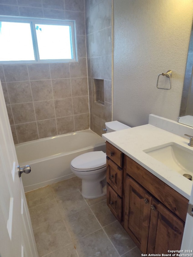 full bathroom featuring toilet, tile patterned floors, vanity, and tiled shower / bath combo