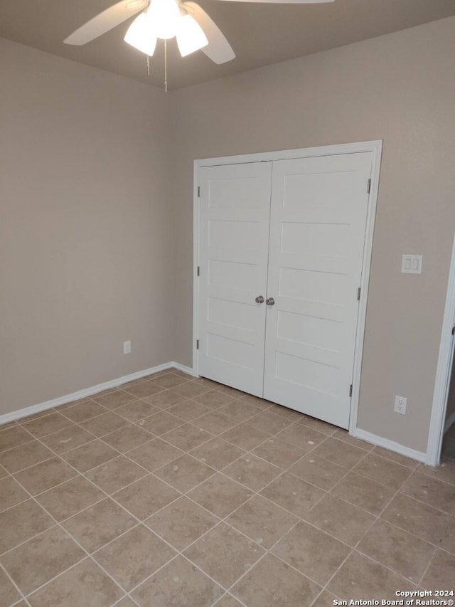 unfurnished bedroom with ceiling fan, a closet, and light tile patterned flooring