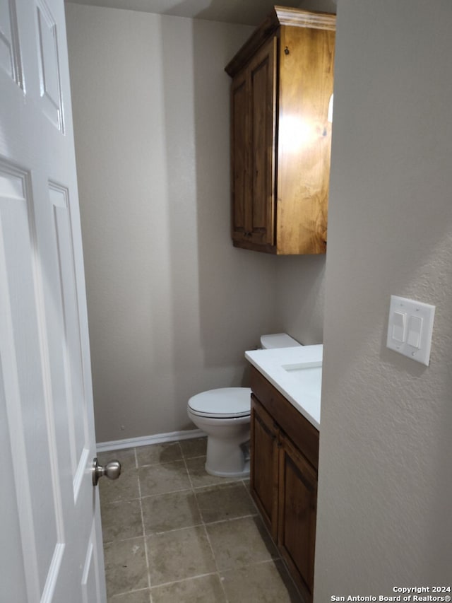 bathroom featuring tile patterned flooring, vanity, and toilet