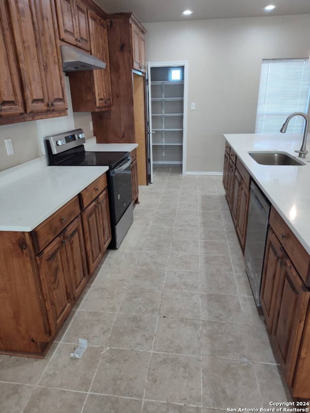 kitchen with light tile patterned floors, stainless steel appliances, and sink