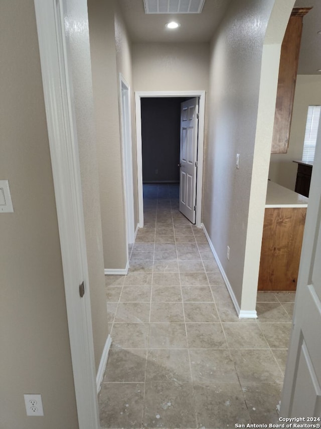 hall with light tile patterned floors