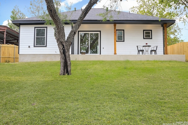 rear view of house featuring a lawn