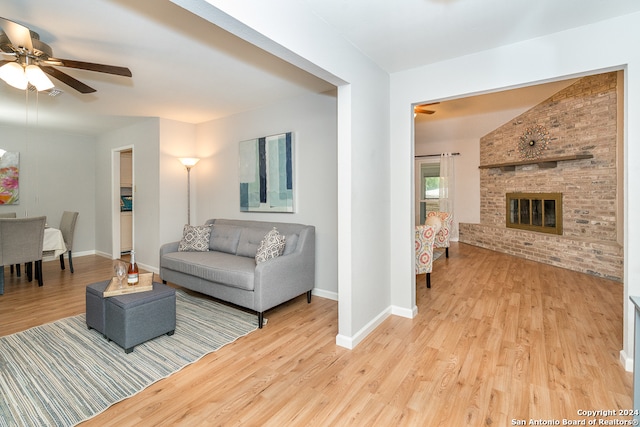 living room featuring a fireplace, ceiling fan, and light hardwood / wood-style flooring