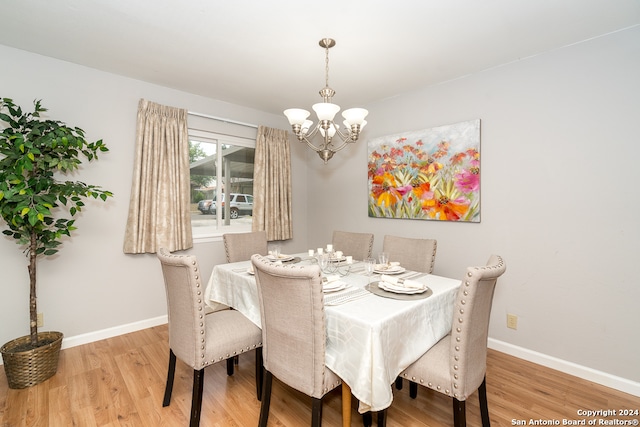 dining space featuring hardwood / wood-style flooring and a notable chandelier