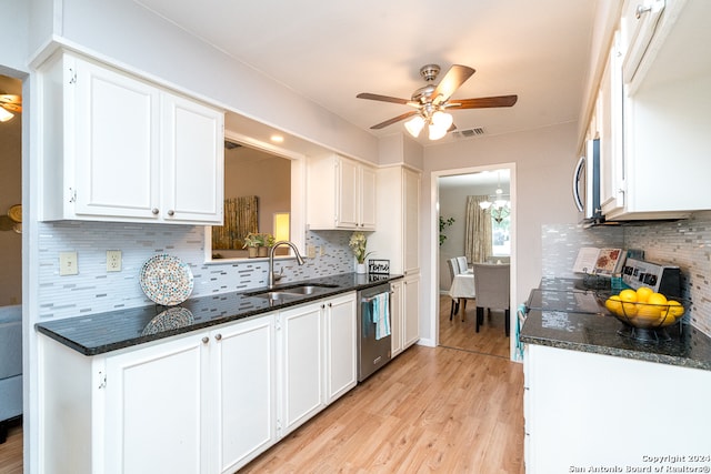 kitchen with tasteful backsplash, stainless steel appliances, sink, light hardwood / wood-style floors, and white cabinetry