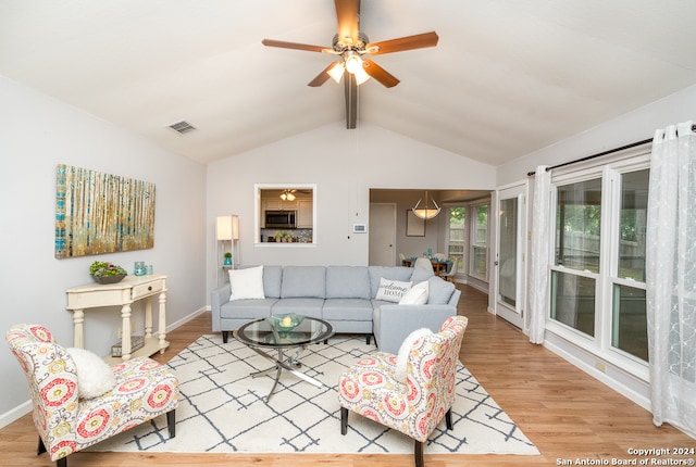 living room featuring vaulted ceiling with beams, light wood-type flooring, and ceiling fan