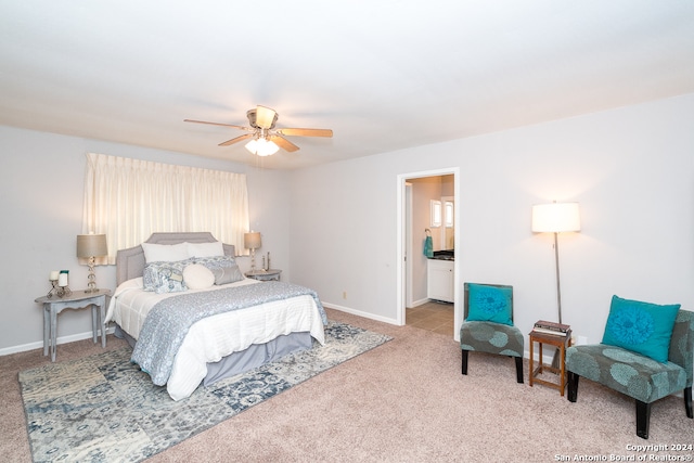 carpeted bedroom with ensuite bathroom and ceiling fan