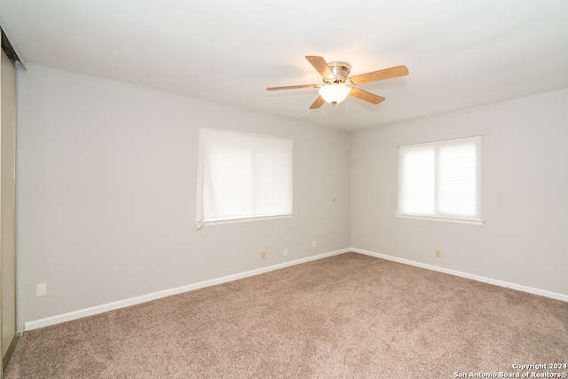 carpeted spare room with ceiling fan