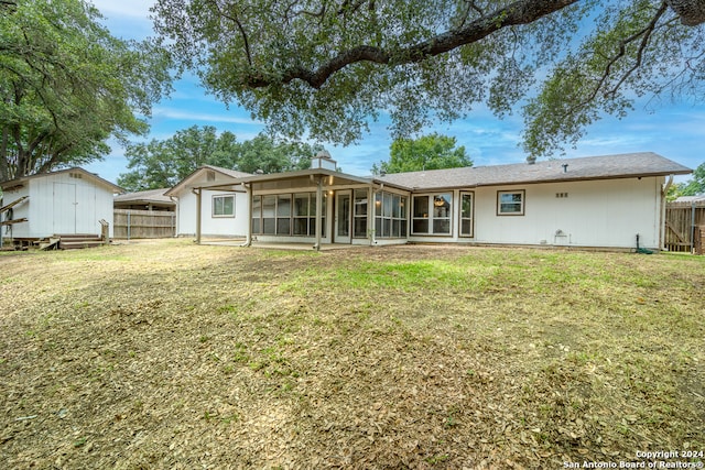 back of house featuring a storage shed and a lawn