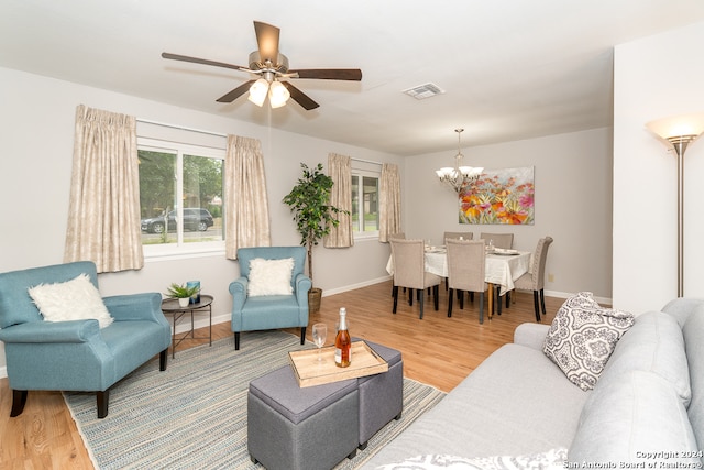 living room with hardwood / wood-style flooring and ceiling fan with notable chandelier