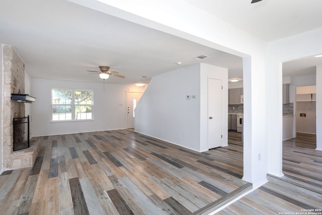 unfurnished living room featuring a fireplace, hardwood / wood-style floors, and ceiling fan