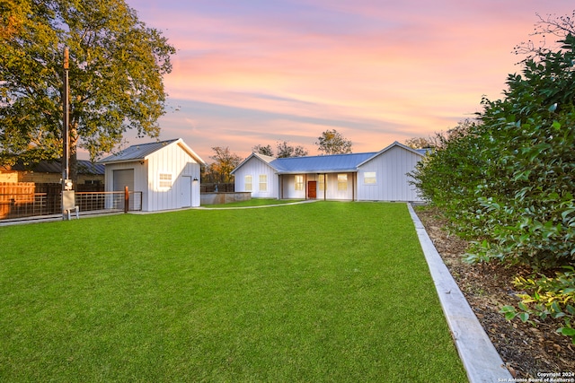 yard at dusk featuring an outbuilding and a garage