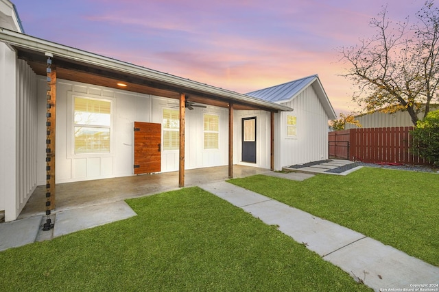 exterior space with a lawn and ceiling fan