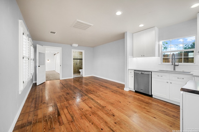 kitchen with dishwasher, sink, decorative backsplash, light hardwood / wood-style floors, and white cabinetry