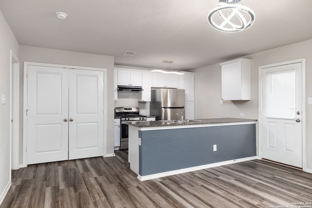 kitchen featuring white cabinets, appliances with stainless steel finishes, dark hardwood / wood-style floors, and pendant lighting