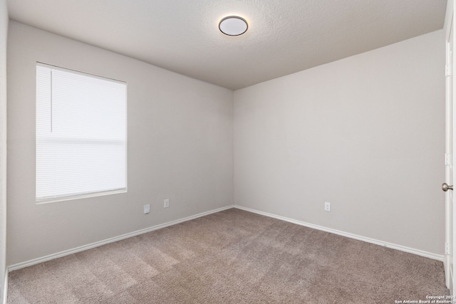 carpeted spare room featuring a textured ceiling