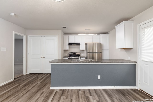 kitchen featuring white cabinets, dark hardwood / wood-style flooring, light stone countertops, and stainless steel appliances