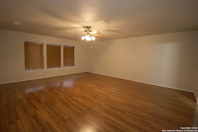 unfurnished room with ceiling fan, dark hardwood / wood-style flooring, and a textured ceiling