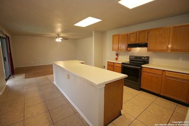 kitchen featuring ceiling fan, a kitchen island, light tile patterned floors, and black electric range