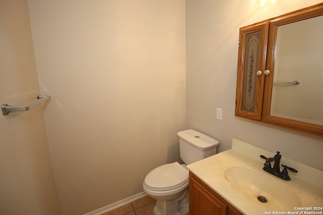 bathroom with tile patterned flooring, vanity, and toilet