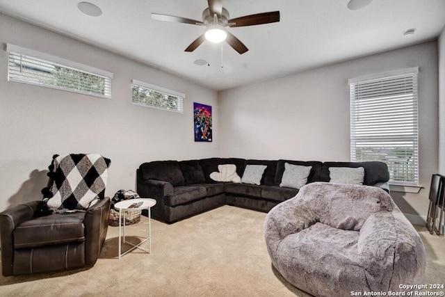 living room with a wealth of natural light, ceiling fan, and light colored carpet