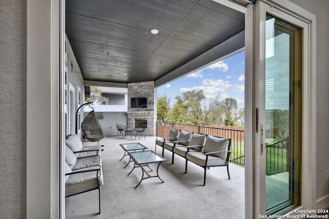 view of patio with an outdoor living space with a fireplace