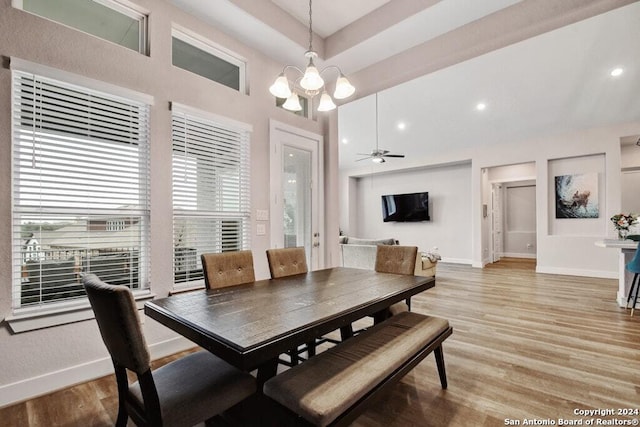 dining area with ceiling fan with notable chandelier and light wood-type flooring