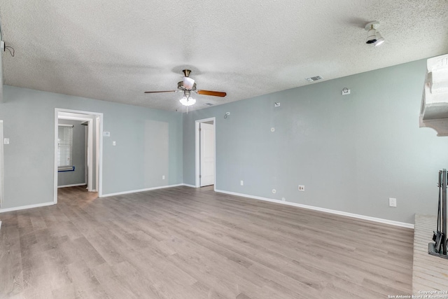 spare room with ceiling fan, light hardwood / wood-style floors, and a textured ceiling