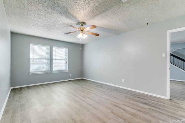 spare room featuring a textured ceiling, light hardwood / wood-style flooring, and ceiling fan