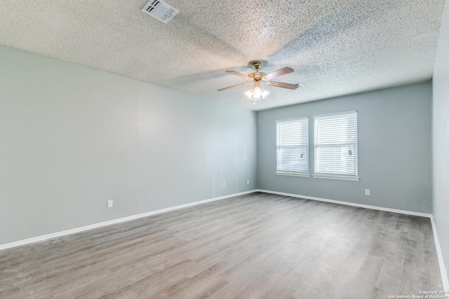 empty room featuring ceiling fan, a textured ceiling, and light wood-type flooring