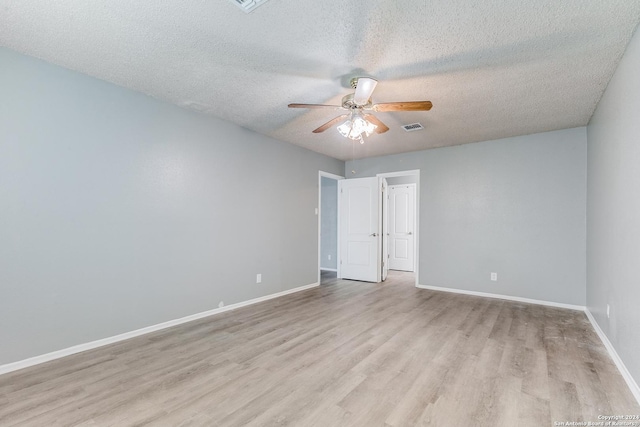 spare room featuring ceiling fan, light hardwood / wood-style floors, and a textured ceiling