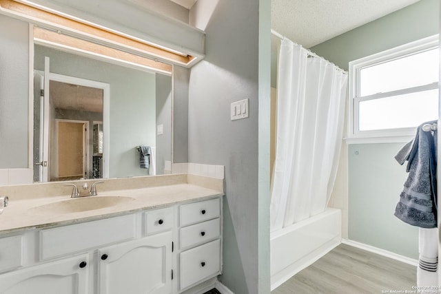 bathroom with hardwood / wood-style flooring, vanity, a textured ceiling, and shower / tub combo with curtain