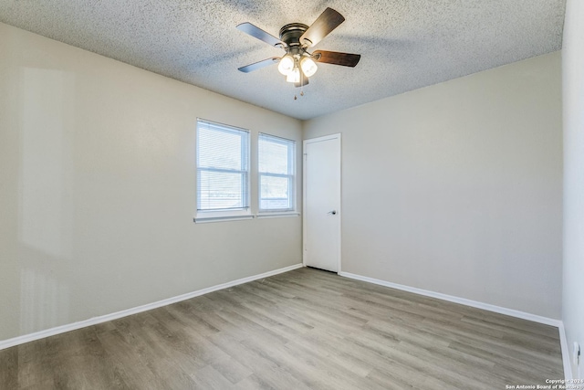 empty room with a textured ceiling, light hardwood / wood-style floors, and ceiling fan