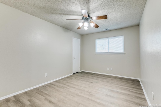 empty room with a textured ceiling, light hardwood / wood-style floors, and ceiling fan