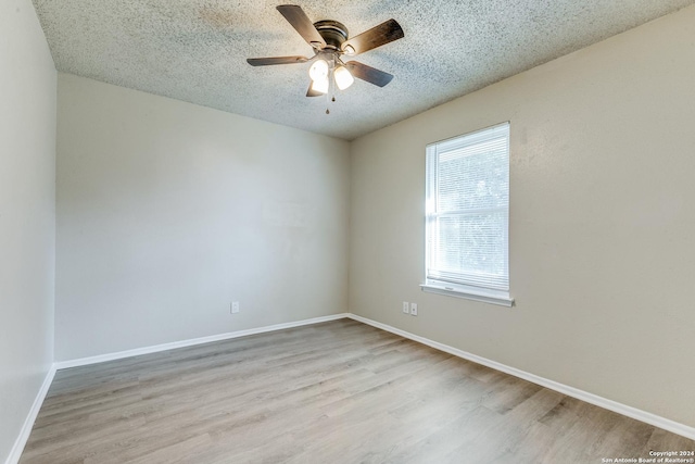 spare room with a textured ceiling, light hardwood / wood-style flooring, and ceiling fan