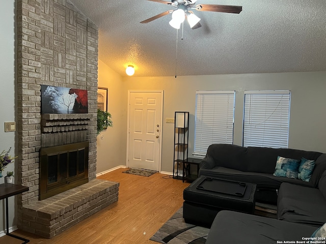 living room with ceiling fan, wood-type flooring, a textured ceiling, and vaulted ceiling