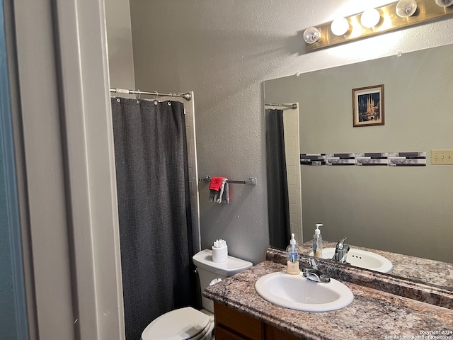 bathroom featuring vanity, curtained shower, and toilet