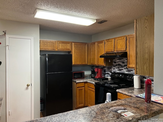 kitchen featuring tasteful backsplash, black appliances, and a textured ceiling