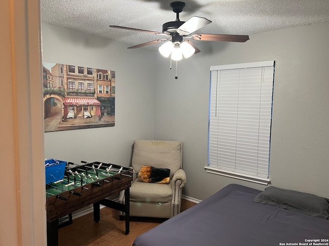 bedroom with hardwood / wood-style floors, a textured ceiling, and ceiling fan