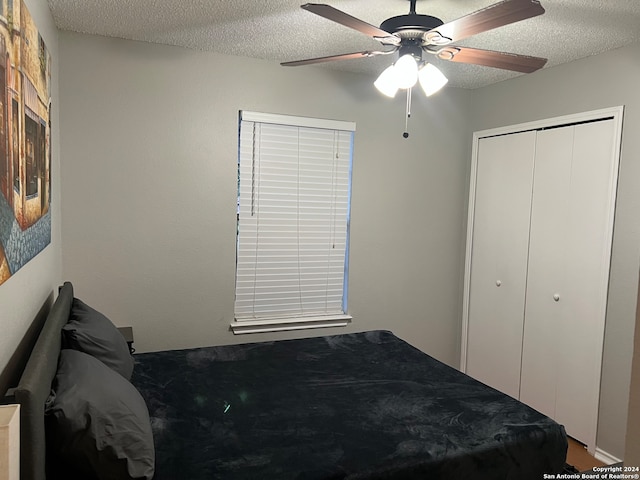 bedroom featuring a textured ceiling, a closet, and ceiling fan