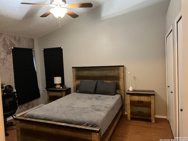 bedroom featuring ceiling fan, light hardwood / wood-style floors, a textured ceiling, and vaulted ceiling