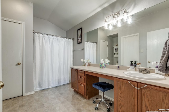 bathroom featuring vaulted ceiling and vanity