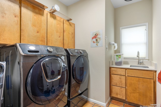 clothes washing area with washing machine and clothes dryer, light tile patterned floors, cabinets, and sink