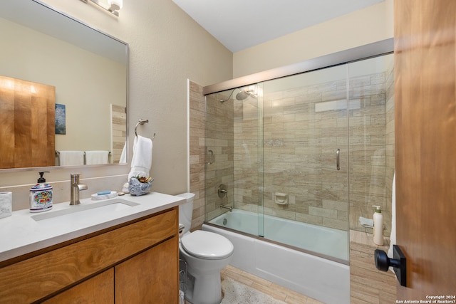 full bathroom with vanity, toilet, and shower / bath combination with glass door