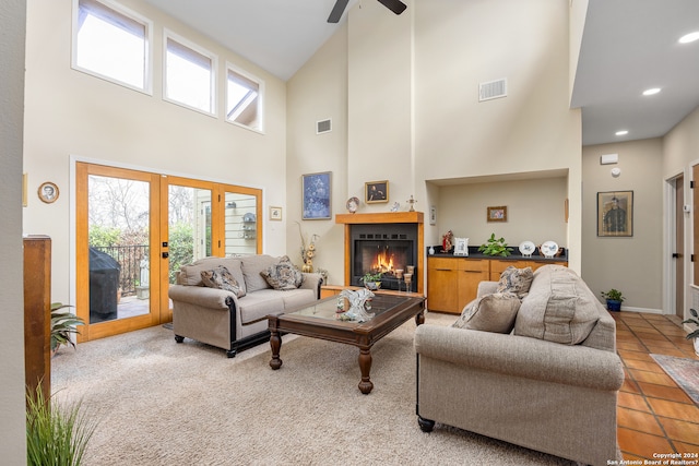 tiled living room featuring ceiling fan, french doors, and a high ceiling