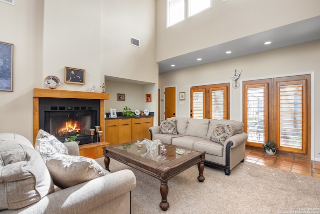 living room with light tile patterned floors and a high ceiling